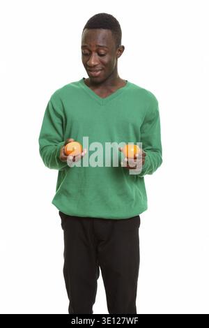 Young happy African man smiling and holding two oranges isolated against white background Stock Photo