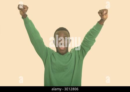 Young happy African man smiling and looking excited Stock Photo