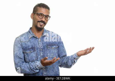 Young happy Indian man showing something isolated against white background Stock Photo