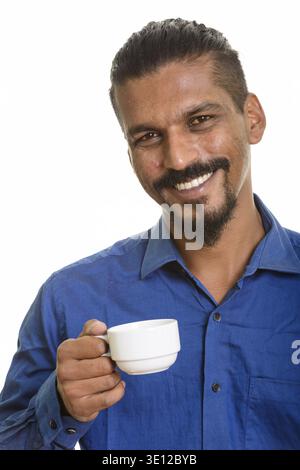 Young happy Indian businessman drinking coffee isolated against white background Stock Photo