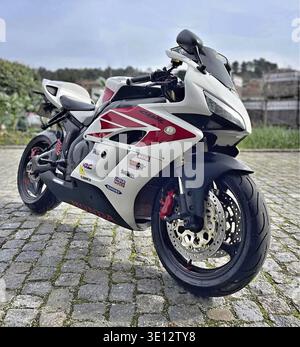 Honda CBR sportbike displaying its design and details while parked on a traditional cobblestone street Stock Photo