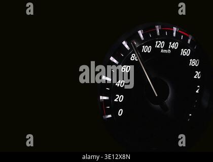 Close-up of car speedometer showing increasing speed on dark background Stock Photo