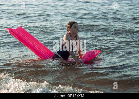 Children playing by the shore of the Baltic Sea in Poland. Girls playing in the water during summer vacation. Family holiday by the sea. Active leisur Stock Photo