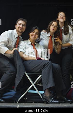 Diverse group of young students smiling, wearing matching uniforms, and posing for a portrait Stock Photo