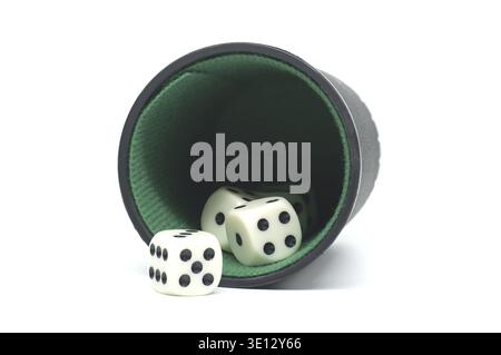 Four white dice with black dots spill out of a black cup, isolated on white Stock Photo