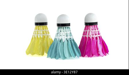A close-up studio shot presents three colorful badminton shuttlecocks, each a different hue against a clean, white backdrop. The shot highlights the v Stock Photo