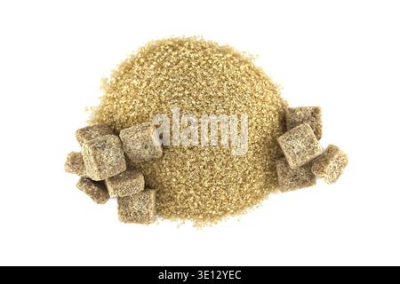 Overhead shot featuring a heap of raw brown sugar granules, alongside symmetrically placed brown sugar cubes on a white backdrop Stock Photo