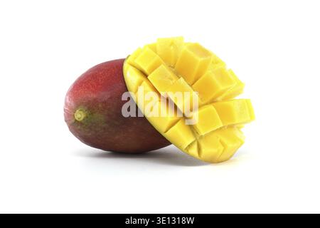 A ripe mango sliced open to display its bright yellow flesh, complemented by a whole mango Stock Photo