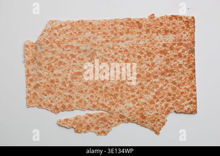 Texture shows slight wear and uneven edges.   The surface of a golden-brown baked piece of lavash. Stock Photo