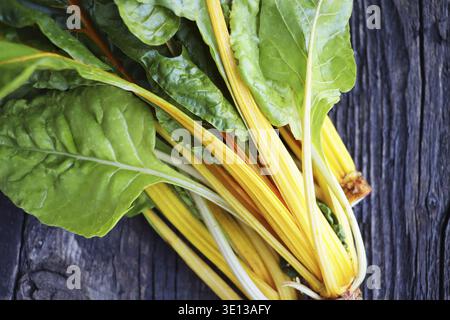 Fresh raw swiss rainbow chard leaves on wooden background. Top view Stock Photo