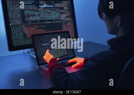 Man using computer and programming to break code. Cyber security threat. Internet and network security. Stealing private information. Person using tec Stock Photo