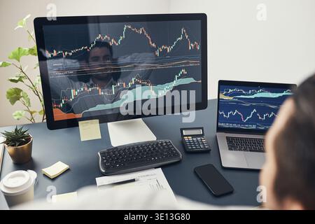 Businessman trading stocks online. Stock investor analysing numbers at graphs and charts. Investor planning and analysing stock market profiit. Man wo Stock Photo
