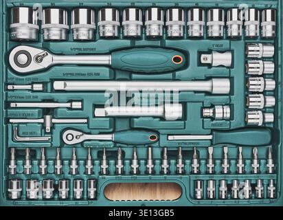 Ratchet with many attachments in plastic case. Work tools. Universal tool set. Background Stock Photo