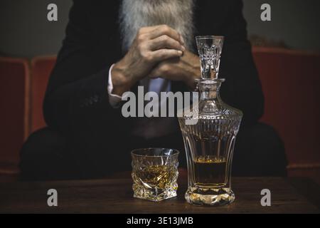 Stylish and handsome bearded senior man drinking whiskey Stock Photo