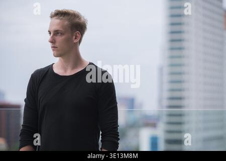 Portrait of young handsome man with curly hair outdoors Stock Photo