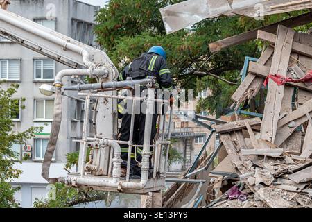 Rescue workers clearing rubble at damaged building site using aerial platform Stock Photo