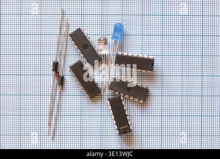 Electronic circuit components on the graph paper. Semiconductor parts as integrated circuits, diodes and leds. Stock Photo