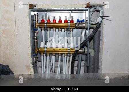 Underfloor heating distributor system with brass manifold and plastic pipes during home construction Stock Photo