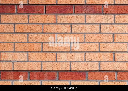 Brick wall with contrasting red and orange bricks in a structured horizontal pattern Stock Photo