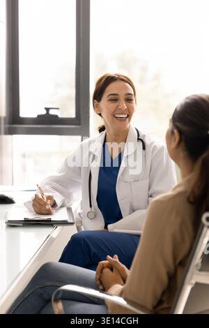 Doctor engaged in positive, friendly conversation with woman patient Stock Photo