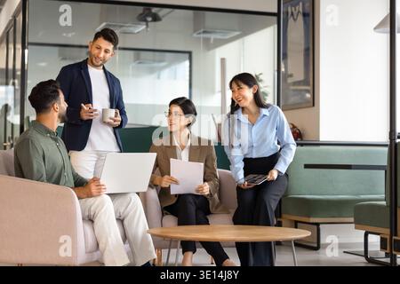 Diverse colleagues discussing business report or ideas in office lounge Stock Photo