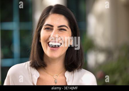 Cheerful young beautiful Hispanic woman posing outdoors for portrait Stock Photo