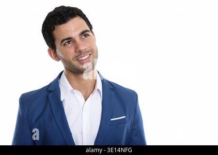 Studio shot of young happy Hispanic businessman smiling while thinking Stock Photo