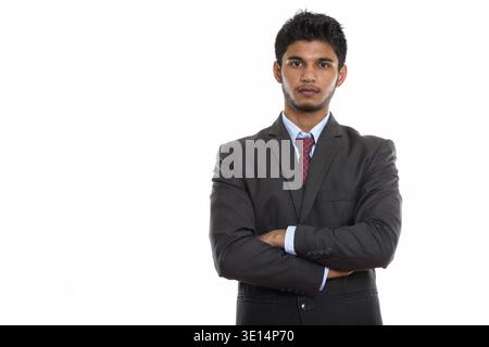 Studio shot of young handsome Indian businessman with arms crossed Stock Photo