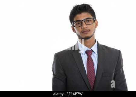 Studio shot of young handsome Indian businessman wearing eyeglasses Stock Photo