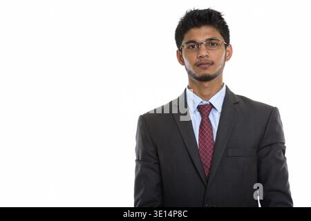Studio shot of young handsome Indian businessman wearing eyeglasses Stock Photo