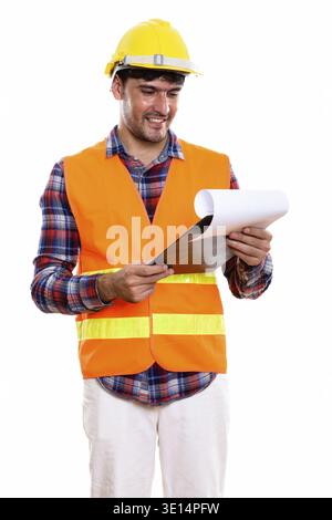 Young happy Persian man construction worker smiling while reading on clipboard Stock Photo
