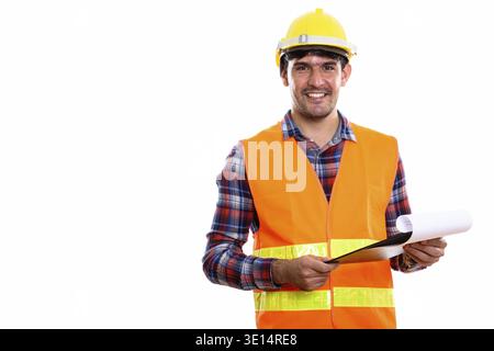 Young happy Persian man construction worker smiling while holding clipboard Stock Photo