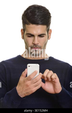 Face of young handsome Persian man using mobile phone touching the screen Stock Photo