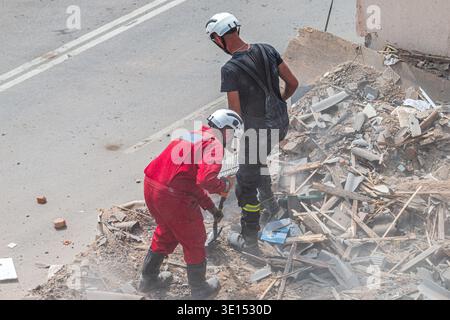 Rescue workers clearing rubble of collapsed building Stock Photo