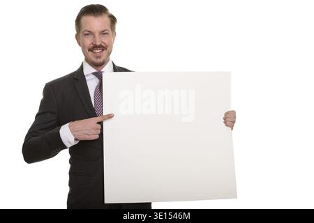 Young happy Caucasian businessman holding copyspace and pointing finger Stock Photo