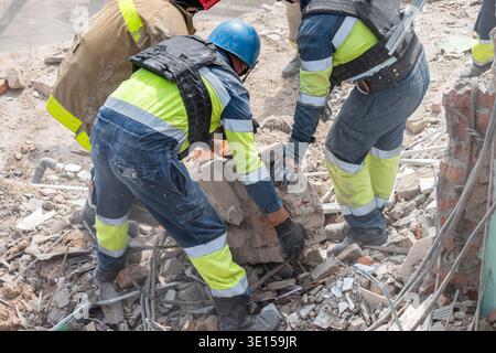 Rescue workers clearing rubble of collapsed building Stock Photo