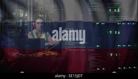 Fixing tech hi-vis red muffs patching yellow LAN cables using laptop near server LEDs, code overlay Stock Photo