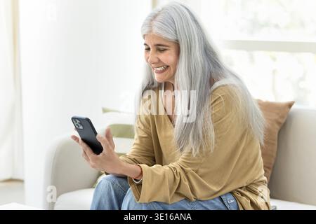 Middle aged Venezuelan woman using modern cellphone Stock Photo
