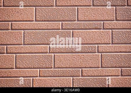 Textured brown brick wall surface creating a repeating pattern and background Stock Photo