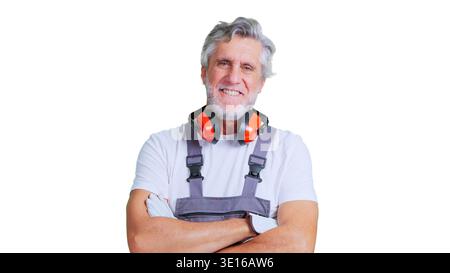 Smiling senior construction worker with safety ear muffs Stock Photo