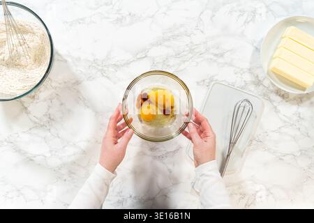 Hands holding bowl of cracked eggs and vanilla Stock Photo