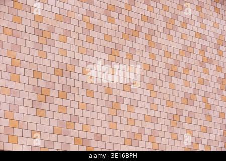Building exterior featuring a patterned facade with decorative orange and pink tiles Stock Photo