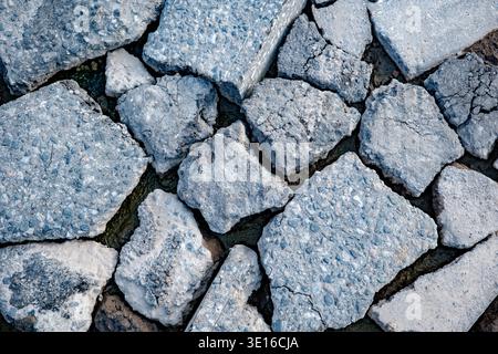 Broken asphalt creating abstract texture of destruction and decay on urban surface Stock Photo