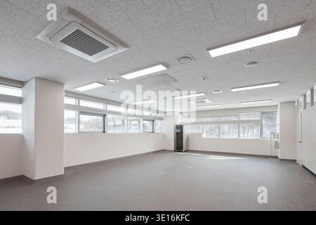 Empty office or classroom floor with wide window bands and white ceiling. Stock Photo