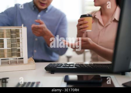 Professional Asian adults review architectural blueprints and discuss building project development They strategize innovative urban planning solutions Stock Photo