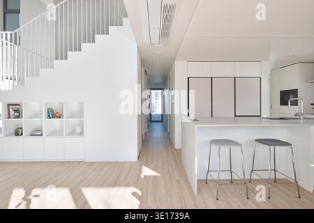 Bright white kitchen and dining space in a minimalist home. Stock Photo
