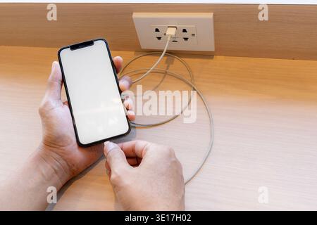 Smartphone charging,plugged into electrical outlet Stock Photo