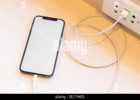 Smartphone charging,plugged into electrical outlet Stock Photo