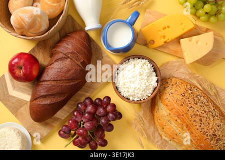 A flat lay of a Shavuot holiday table featuring an assortment of fresh bread, cheese, grapes and apples, elegantly arranged to celebrate this Jewish f Stock Photo