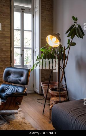 Interior of modern apartment in loft style with glowing floor lamp and comfortable furniture Stock Photo